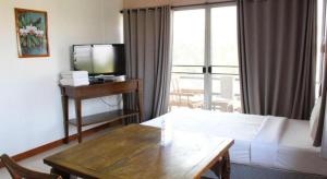 a hotel room with a bed and a table and a television at EASTAN VIEW in Chiang Mai