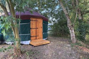 a yurt with a wooden door in the woods at Yourte pour deux - Voie Bleue in Bayon