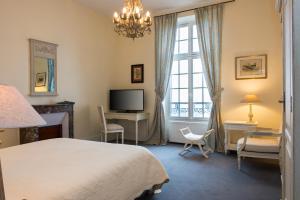 A bed or beds in a room at Hôtel Château de l'Hermitage