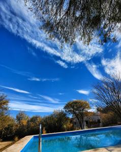 a swimming pool with a blue sky in the background at La Quebrada del Molle in San Marcos Sierras