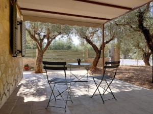 a table and two chairs under an umbrella on a patio at Sweet little studio in Leonidio
