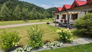 a garden in front of a building with a picnic table at Daglezja in Przyborów