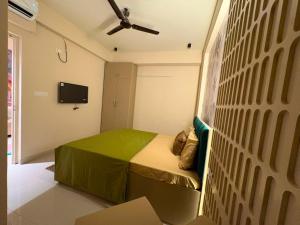 a bedroom with a bed and a wall with a fan at Bright & Modern 1BHK in Ghaziabad