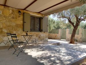 a patio with two chairs and a table and a window at Sweet little studio in Leonidio