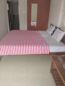 a large bed with a red and white striped mattress at Meenatchi Hotel and Residency in Alāndurai