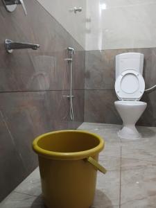a bathroom with a toilet and a large bucket at Meenatchi Hotel and Residency in Alāndurai