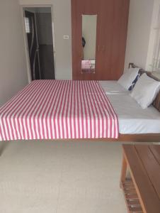 a large bed with a red and white striped mattress at Meenatchi Hotel and Residency in Alāndurai