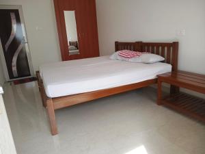 a bed in a bedroom with a wooden frame and a table at Meenatchi Hotel and Residency in Alāndurai