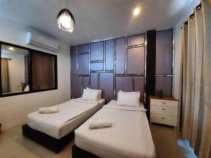 a bedroom with two beds and a mirror at Debua Mahasarakham in Maha Sarakham