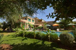 a house with a swimming pool in a yard at Bluegreen Guest House Marrakech in Aït Amara