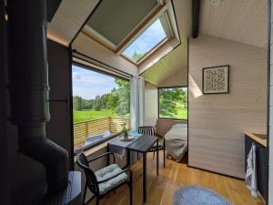 a room with a table and chairs and a window at Suur Muna Apple Garden Tiny Houses in Haanja