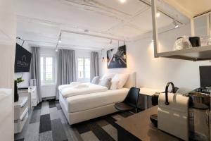a white living room with a white couch and a tv at NOX HOTEL - Digital-Check-In & Virtual Reception - nahe Bretten & Karlsruhe in Wössingen