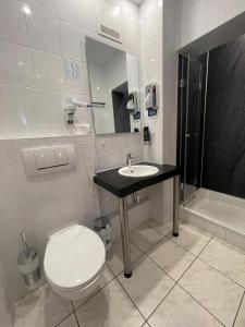 ein Badezimmer mit Toilette, Waschbecken und Badewanne in der Unterkunft Steingarten Hotel in Wertheim + 10 Fotos