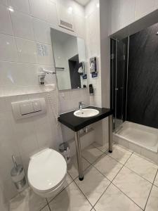 ein Badezimmer mit Toilette, Waschbecken und Dusche in der Unterkunft Steingarten Hotel in Wertheim
