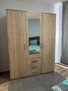 a large wooden cabinet with a mirror in a room at Deluxe apartment Amar in Sarajevo