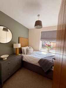 a small bedroom with a bed and a window at The Stokesay Boutique Townhouse Ludlow in Ludlow