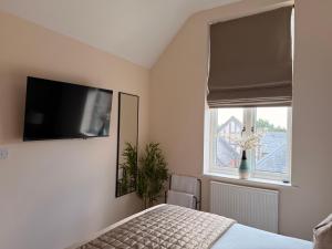 a bedroom with a bed and a television on the wall at The Stokesay Boutique Townhouse Ludlow in Ludlow +10 photos