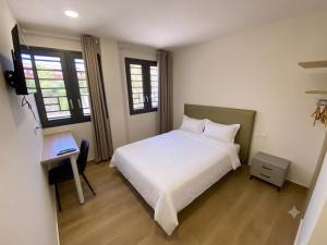 a bedroom with a white bed and a desk at Hotel A&M Mostoles-Alcorcon-M506 in Alcorcón