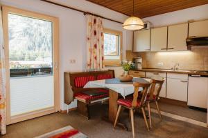 a kitchen with a table and chairs and a window at Almblick Appartements in Sankt Jakob in Defereggen +45 photos