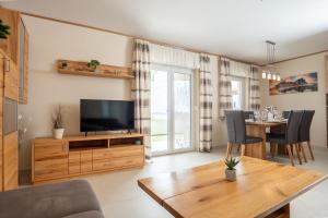 a living room with a television and a dining table at Beachfront Reiterer Villa V2 with Seaview 30 meters from the Beach - CROWONDER LUXURY RENT in Privlaka