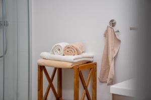 a pile of towels sitting on a stool in a bathroom at Beachfront Reiterer Villa V2 with Seaview 30 meters from the Beach - CROWONDER LUXURY RENT in Privlaka +23 photos