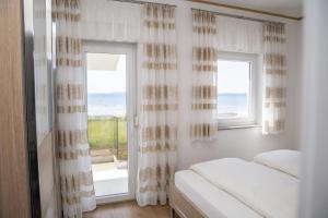 a bedroom with a bed and a window with a view at Beachfront Reiterer Villa V2 with Seaview 30 meters from the Beach - CROWONDER LUXURY RENT in Privlaka