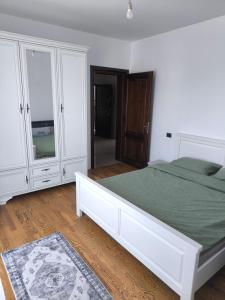 a white bedroom with a bed and white cabinets at Apartament cu 2 camere situat la etajul al doilea in Rădăuţi
