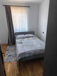 a small bedroom with a bed and a window at Apartament cu 2 camere situat la etajul al doilea in Rădăuţi