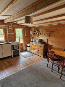 a kitchen with wooden walls and a wooden table in a room at The Cabin - a very quiet location in Pewsey