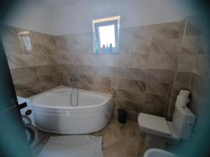 a bathroom with a tub and a toilet and a sink at Apartament cu 2 camere situat la etajul al doilea in Rădăuţi