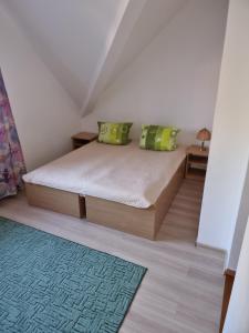 a bedroom with a bed and a rug on the floor at Pokoje Poniatowka in Nałęczów