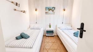 two beds in a room with white walls and blue pillows at Ferienhaus Seeoase - 70qm - Kamin -Terrassen - Parkplatz - Badestelle fußläufig in Joachimsthal