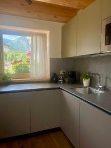 a kitchen with a sink and a window at Mirtillo in Tassullo