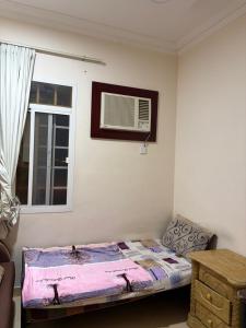 a small bedroom with a bed and a window at Sahnut in Salalah