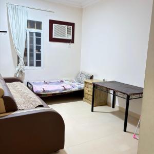 a living room with a table and a couch at Sahnut in Salalah