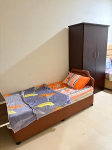 a bedroom with a bed and a cabinet in it at Sahnut in Salalah