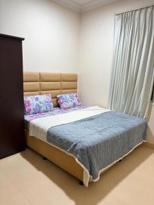 a bedroom with a large bed with a window at Sahnut in Salalah