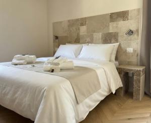 a bedroom with a large white bed with towels on it at Pietra Museum Suites Sirolo in Sirolo