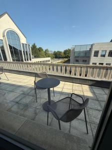 a table and a chair sitting on a balcony at Hotel SKØL in Strassen