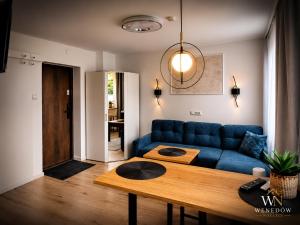 a living room with a blue couch and a table at 104 Wenedów Noclegi in Koszalin