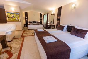 a hotel room with two beds and a couch at Hotel Melnik Хотел Мелник in Melnik +146 photos