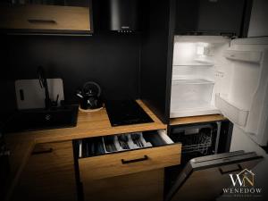 a kitchen with an open refrigerator with a tea kettle at 104 Wenedów Noclegi in Koszalin