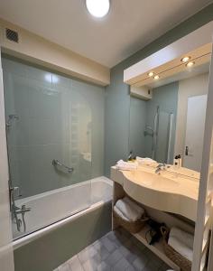 a bathroom with a shower and a sink and a tub at Hôtel La Redoute in Les Rousses +21 photos