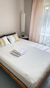 a bed with two towels on top of it at Oja 134 Apartments in Pärnu