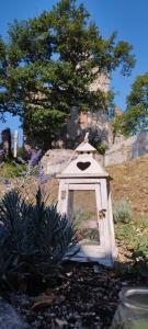 a small white dog house in a garden at Guest House Villa Castello in Nucetto