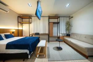 a bedroom with a bed and a couch at ELLEVA STUDIOS | Studio moderno com coworking e rooftop em Sinop in Sinop