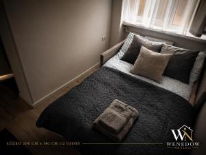 a bedroom with a bed with pillows and a window at 104 Wenedów Noclegi in Koszalin