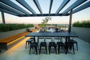 a patio with a table and chairs on a roof at ELLEVA STUDIOS | Studio moderno com coworking e rooftop em Sinop in Sinop