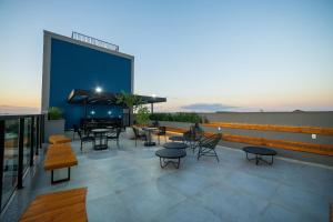 a patio with tables and chairs on a building at ELLEVA STUDIOS | Studio moderno com coworking e rooftop em Sinop in Sinop