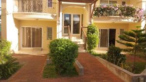 a house with a brick walkway in front of it at Residence Les Peupliers 05-06 in Flic-en-Flac